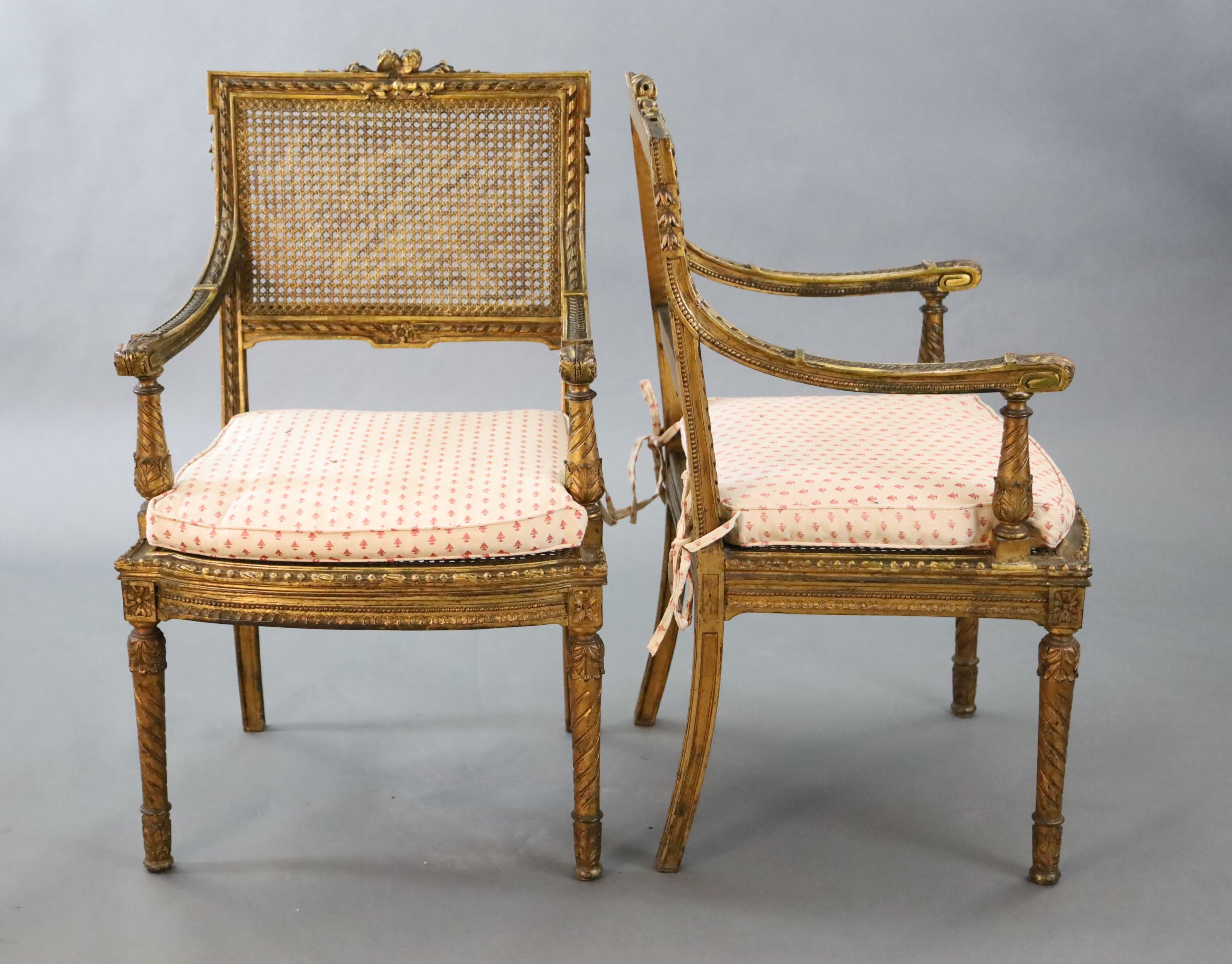 A pair of Louis XVI style walnut giltwood fauteuils, W.1ft 10in. D.1ft 9in. H.3ft 1in.